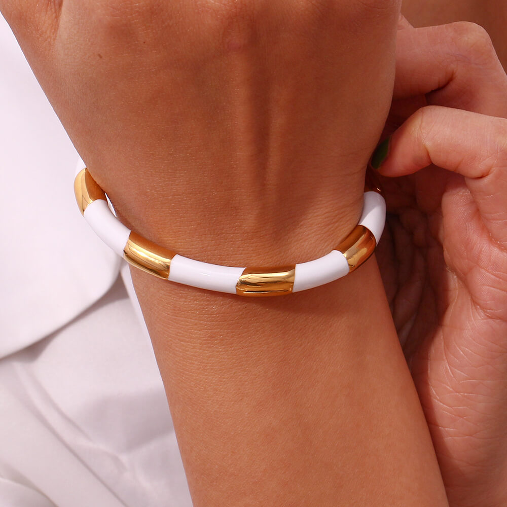 A model wearing the White Enamel Gold Bangle.