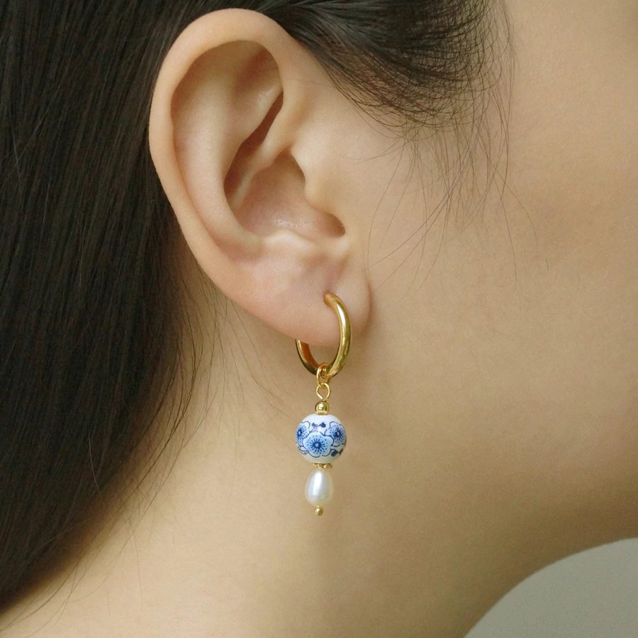 A model wearing the Blue & White Ceramic Pearl Earrings.