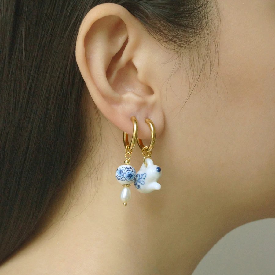 A model wearing the Blue & White Tea Kettle Mix-Matched Earrings.