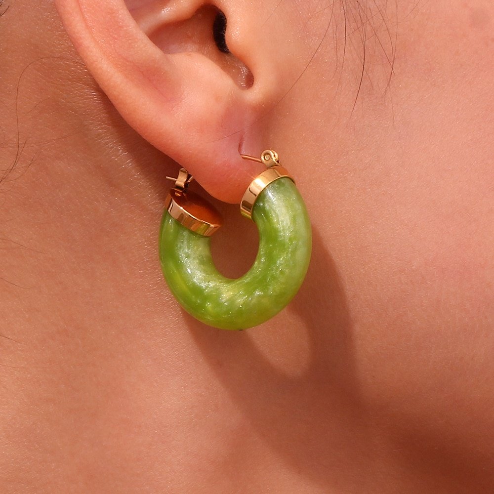A model wearing shimmer green Chunky Acrylic Hoops.