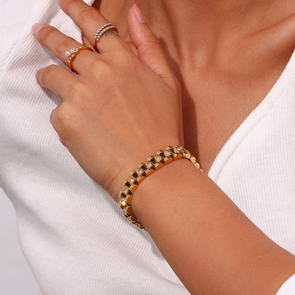 A model wearing a chunky gold bracelet.