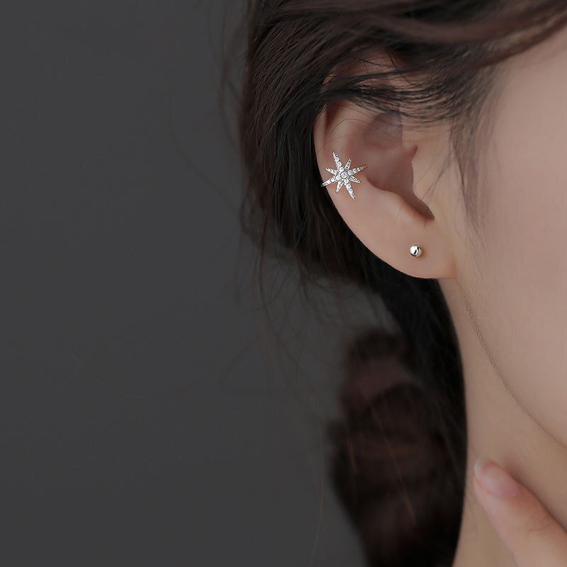 A model wearing a sparkly star ear cuff.