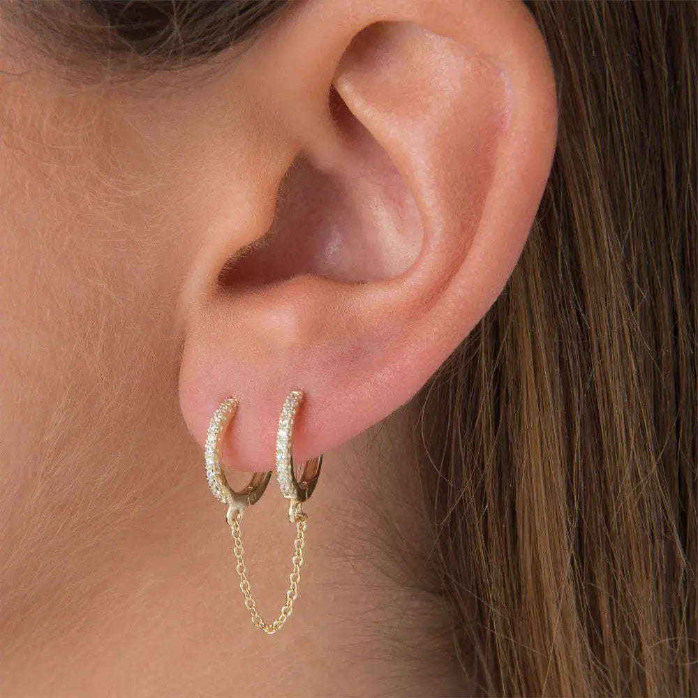 A model wearing a double hoop chain earring.