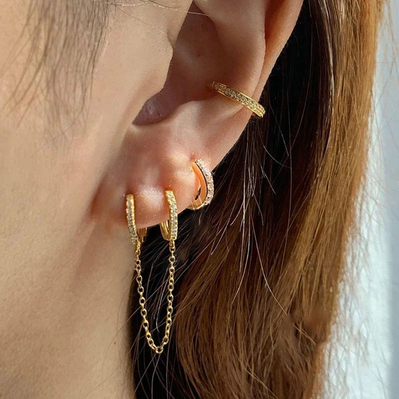 A woman wearing a huggie chain earring.
