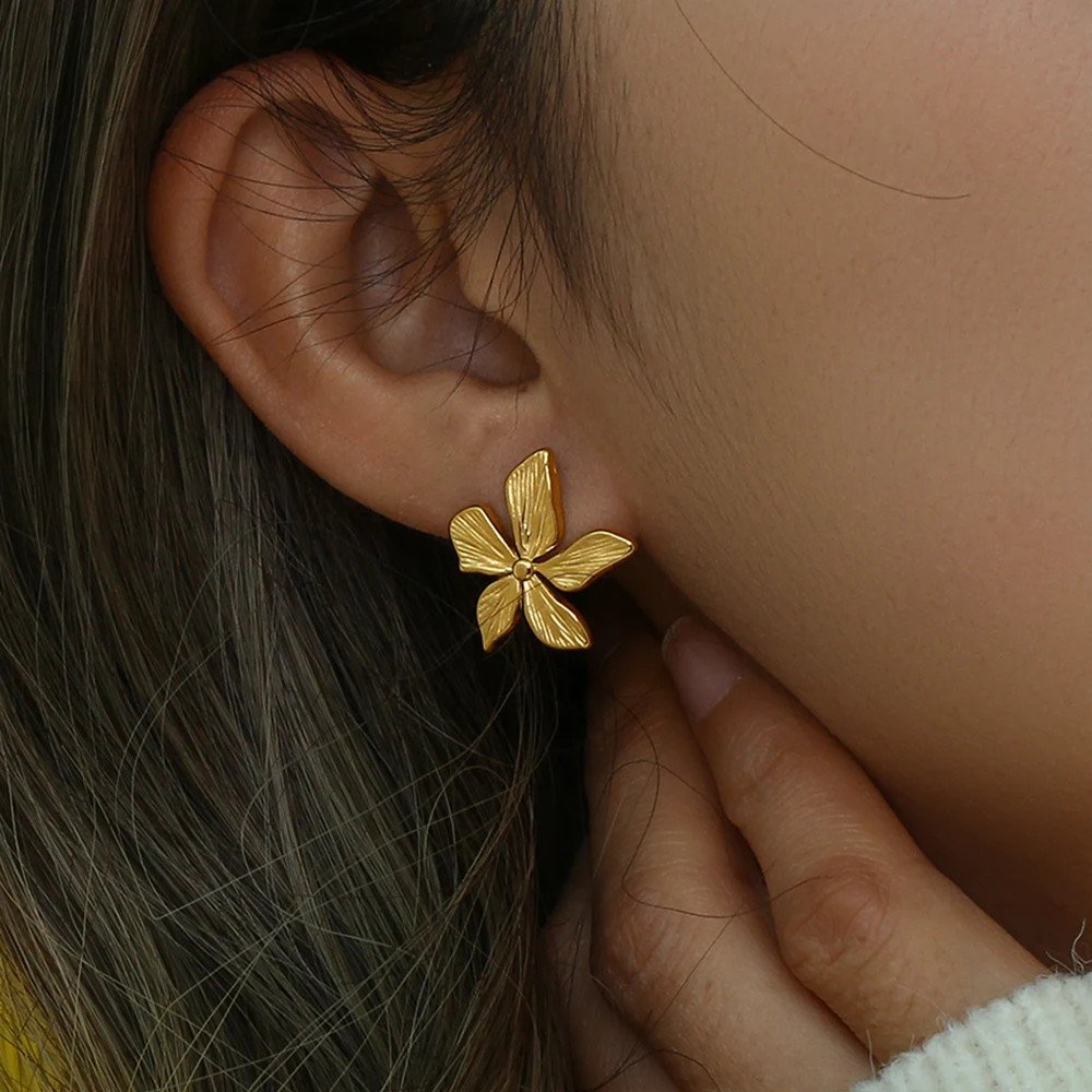 A model wearing the Lily Flower Gold Earrings.