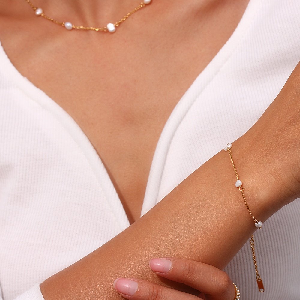 A woman wearing a pearl beacelet.