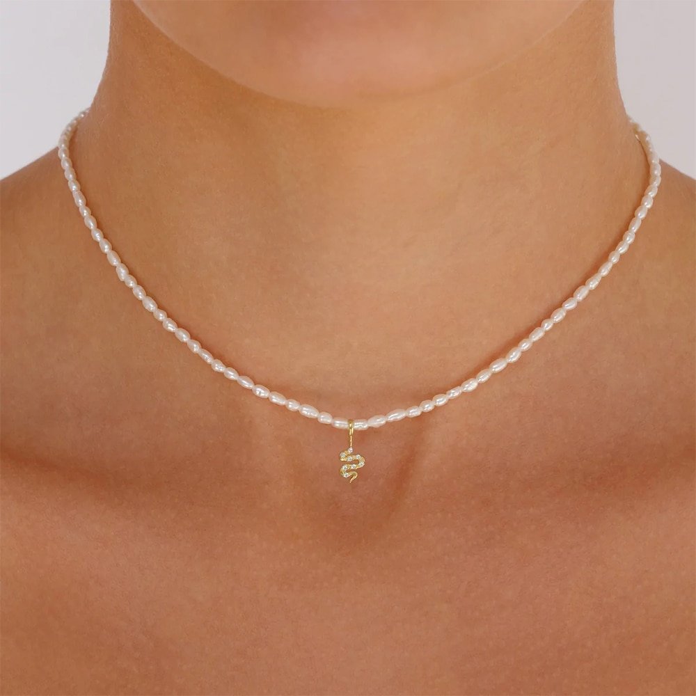 A model wearing the Snake Pearl Charm Gold Necklace.