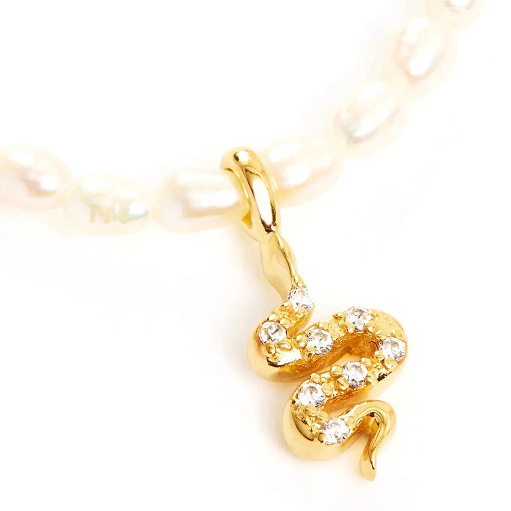 Closeup of the Snake Pearl Charm Gold Necklace.