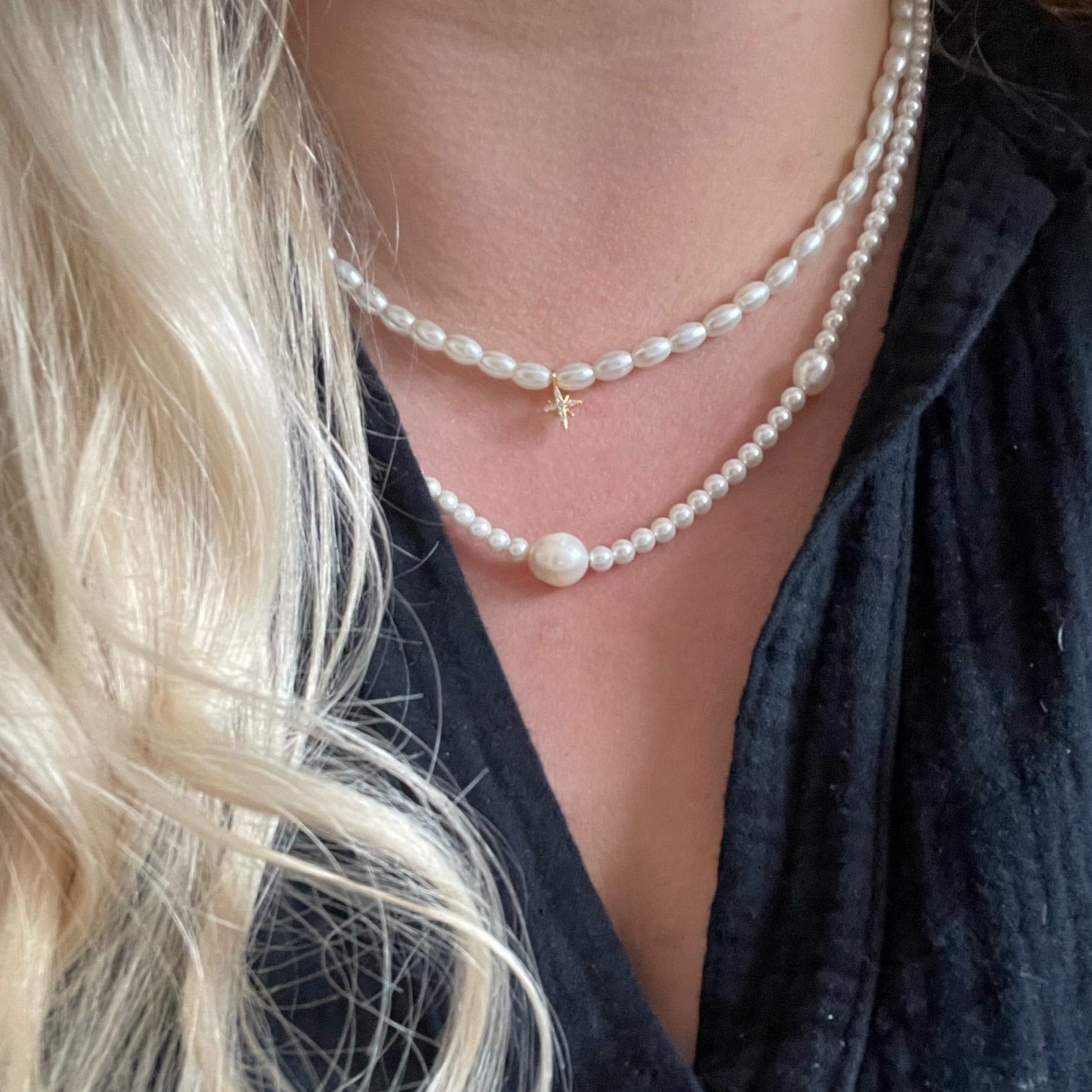 A woman wearing layered pearl necklaces.