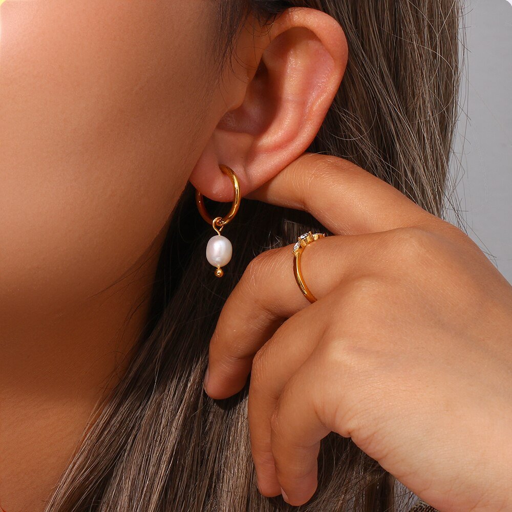 A model wearing the Pearl Dangle Gold Hoops.