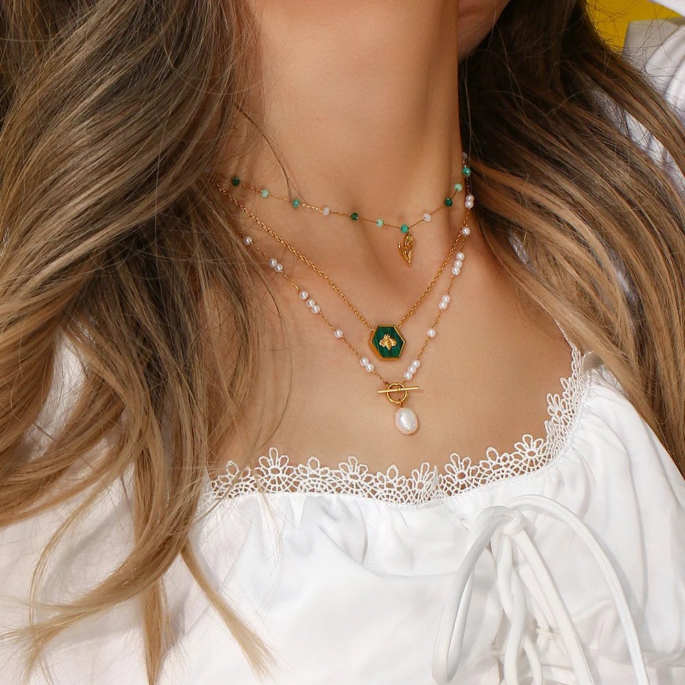 A woman wearing multiple layering necklaces.