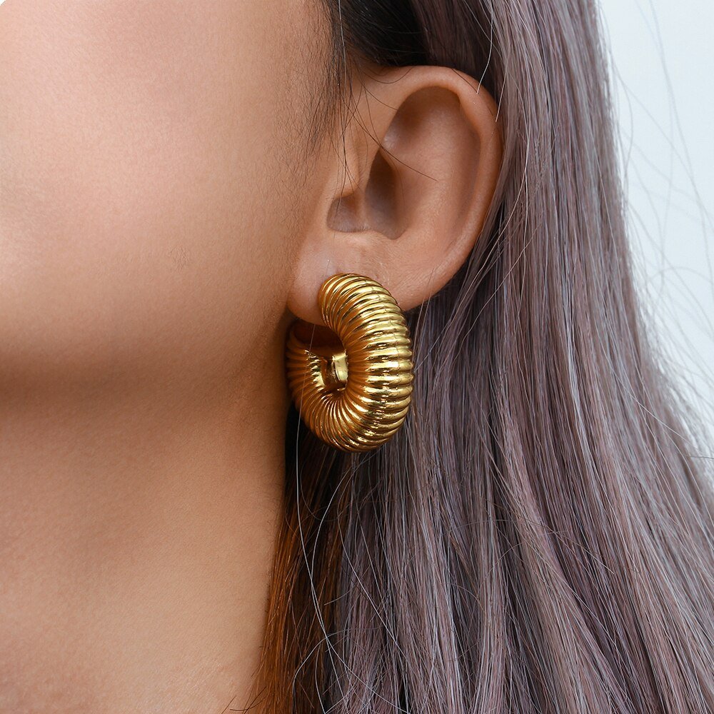 A model wearing the Textured Chunky Gold Hoops.