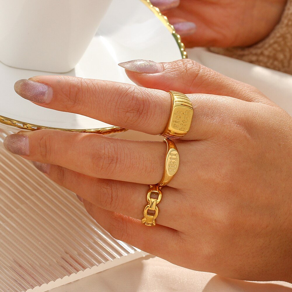 A woman wearing gold signet rings.