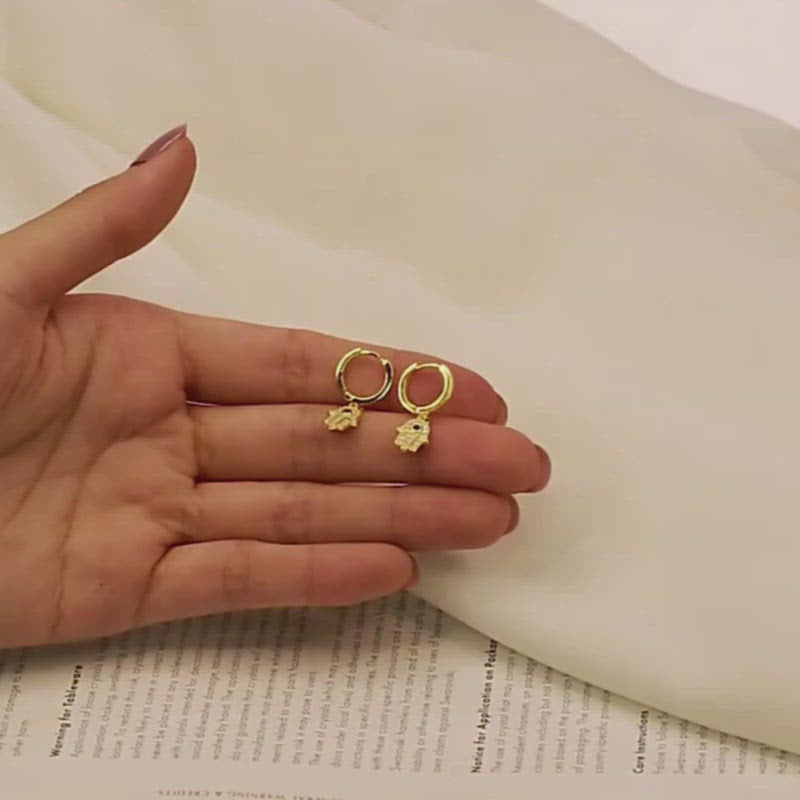 Short video of a model displaying how the Hamsa Hand CZ Huggies open.