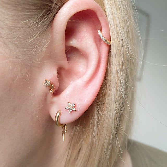 A model wearing multiple cartilage piercings.