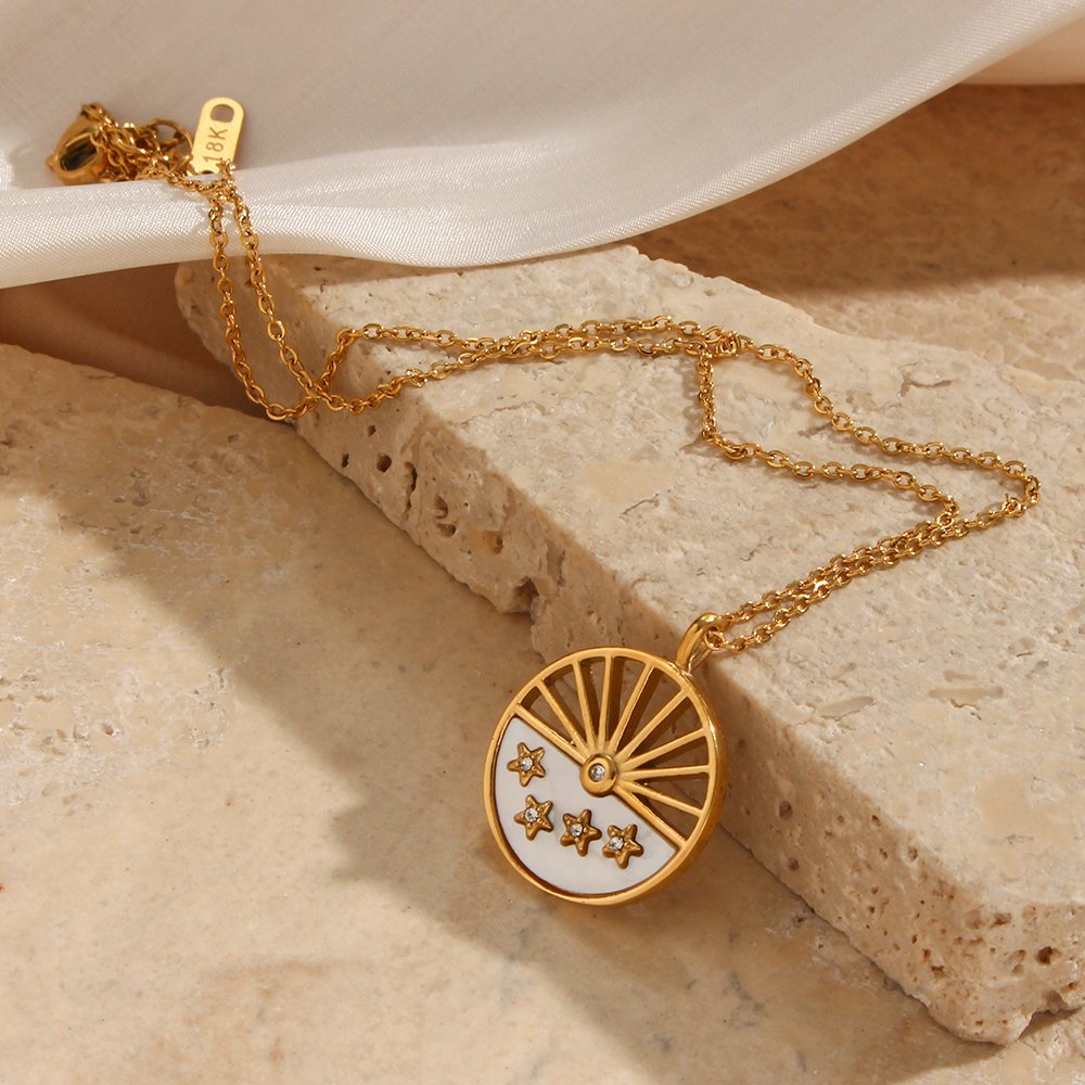 Closeup of the sun and star gold pendant necklace.