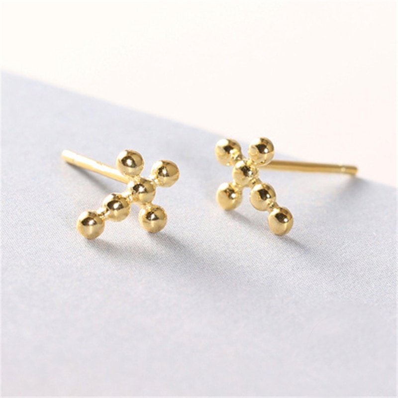 Beaded Cross Studs on a light colored table.