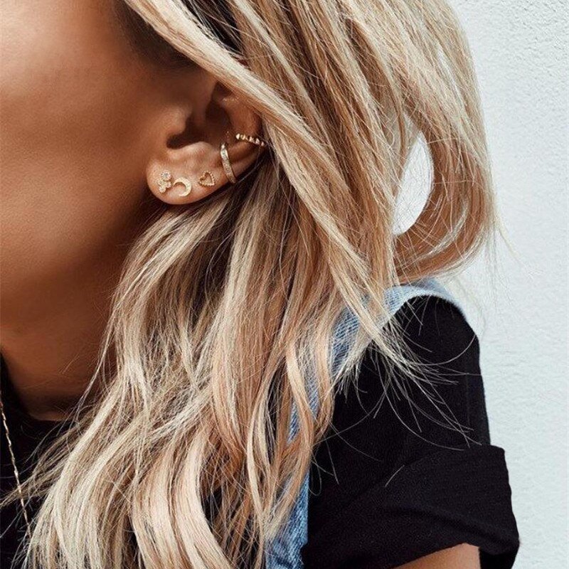 A woman wearing multiple gold earrings.