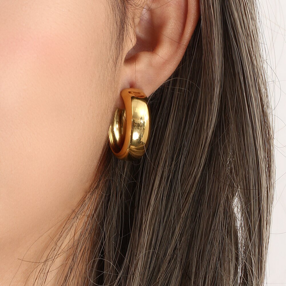 A model wearing the Bianca Gold Hoop Earrings.