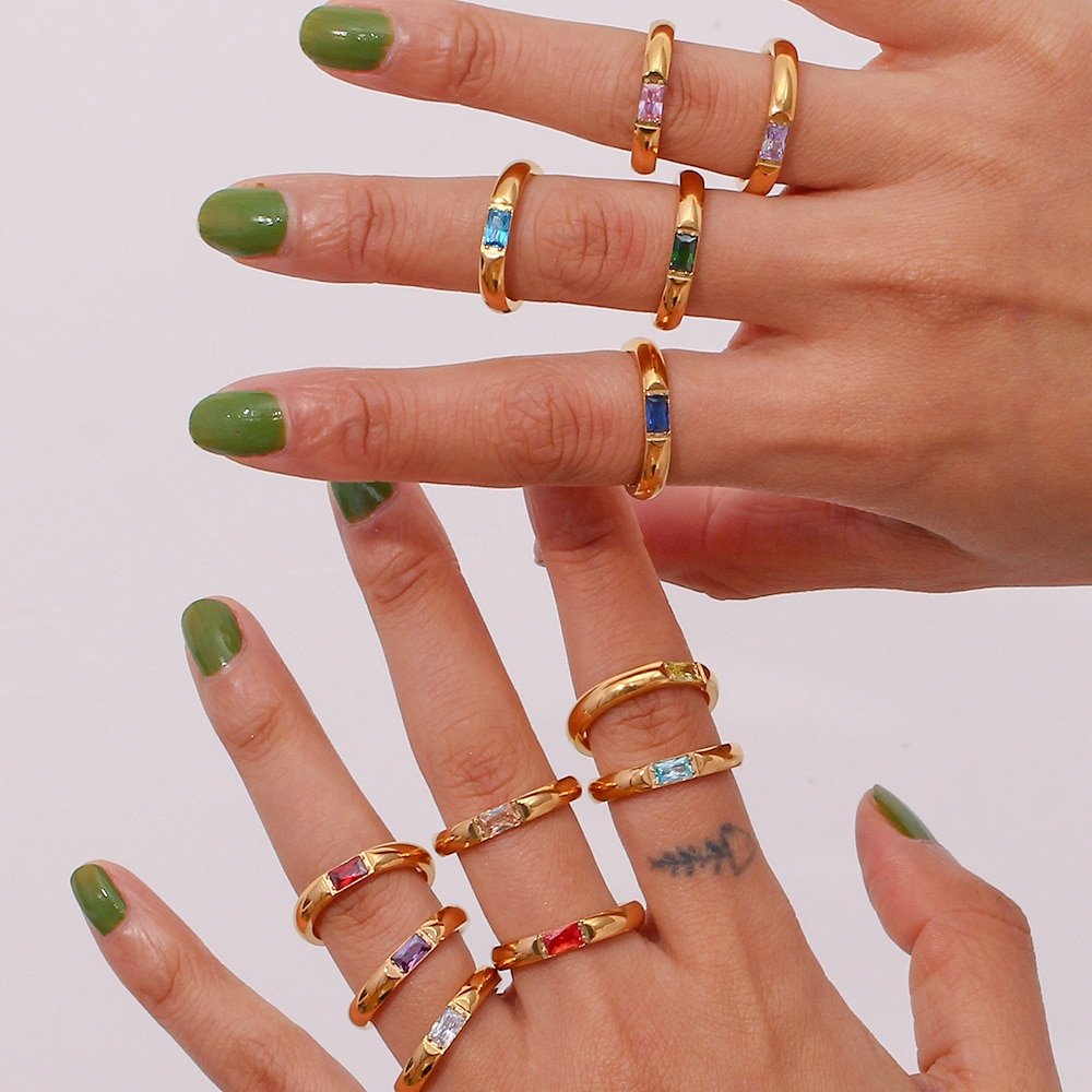 A woman wearing multiple Birthstone CZ Gold Ring Bands.