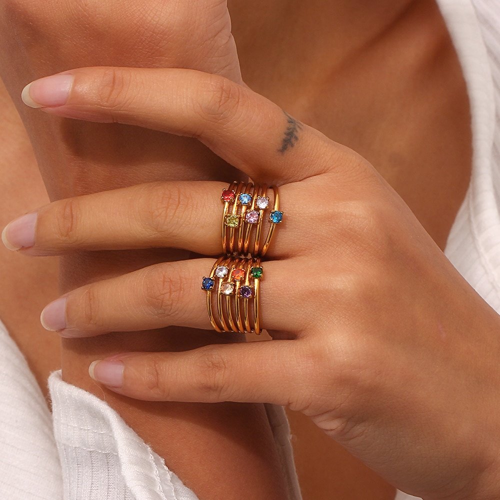 A model wearing multiple birthstone stacking rings.