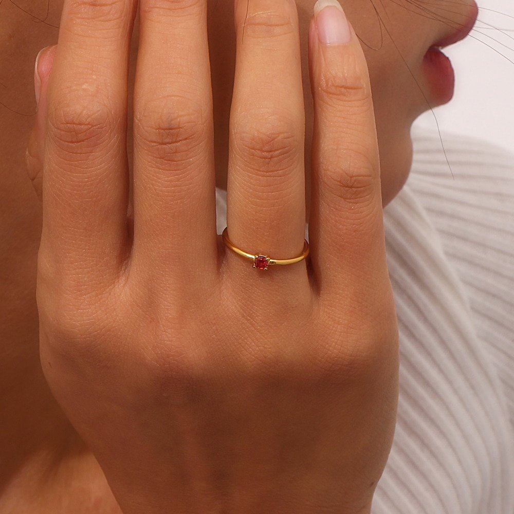 A woman wearing a birthstone CZ stacking ring.