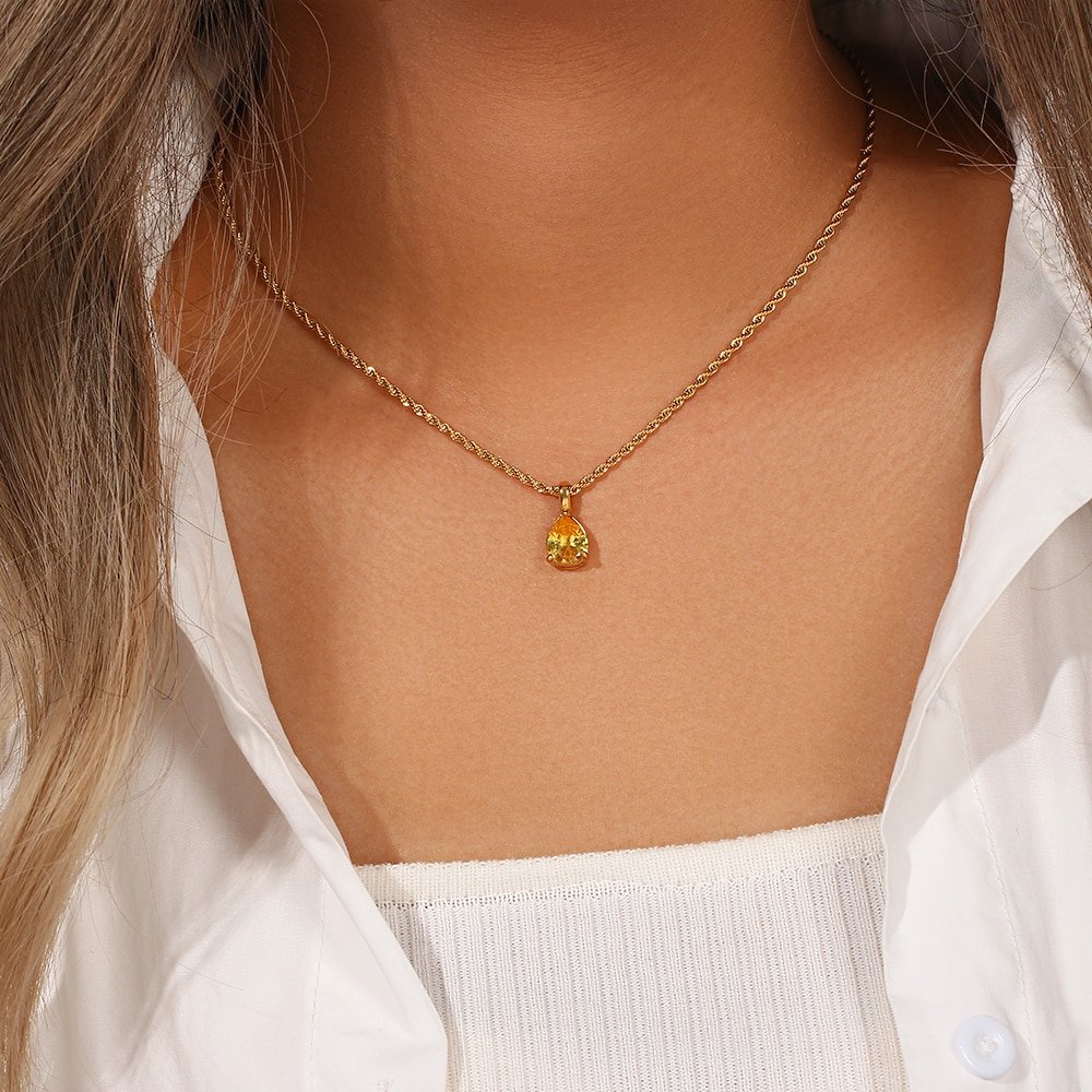 A woman wearing an August Birthstone CZ Teardrop Gold Necklace.