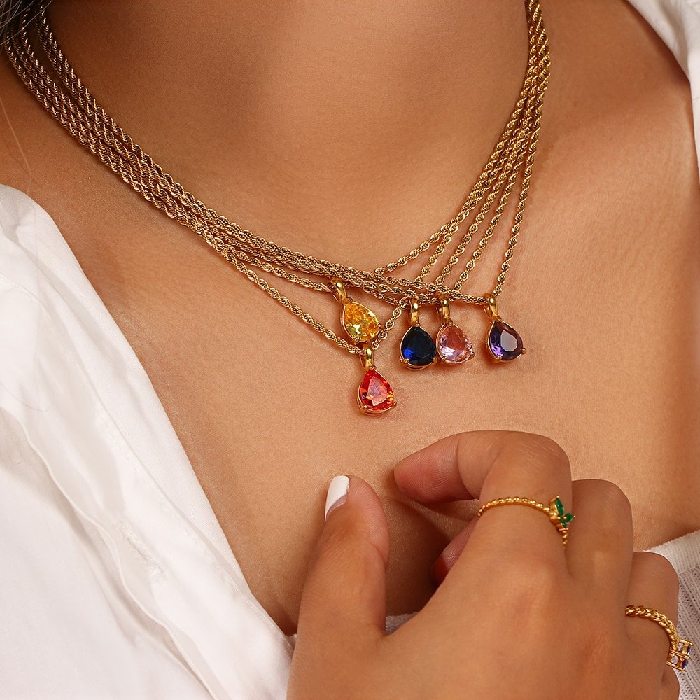 A model wearing multiple Birthstone CZ Teardrop Gold Necklaces.