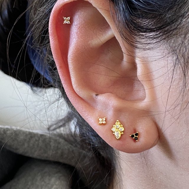 A woman wearing Black Zircon Trinity Studs.