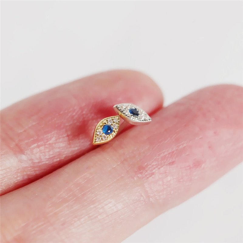A woman's hand hold the Blue CZ Evil Eye Studs in their hand.