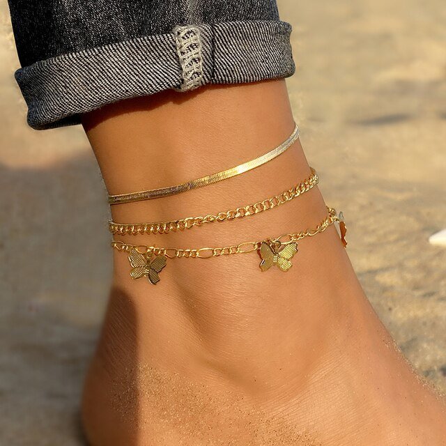 A model wearing multiple gold anklets.