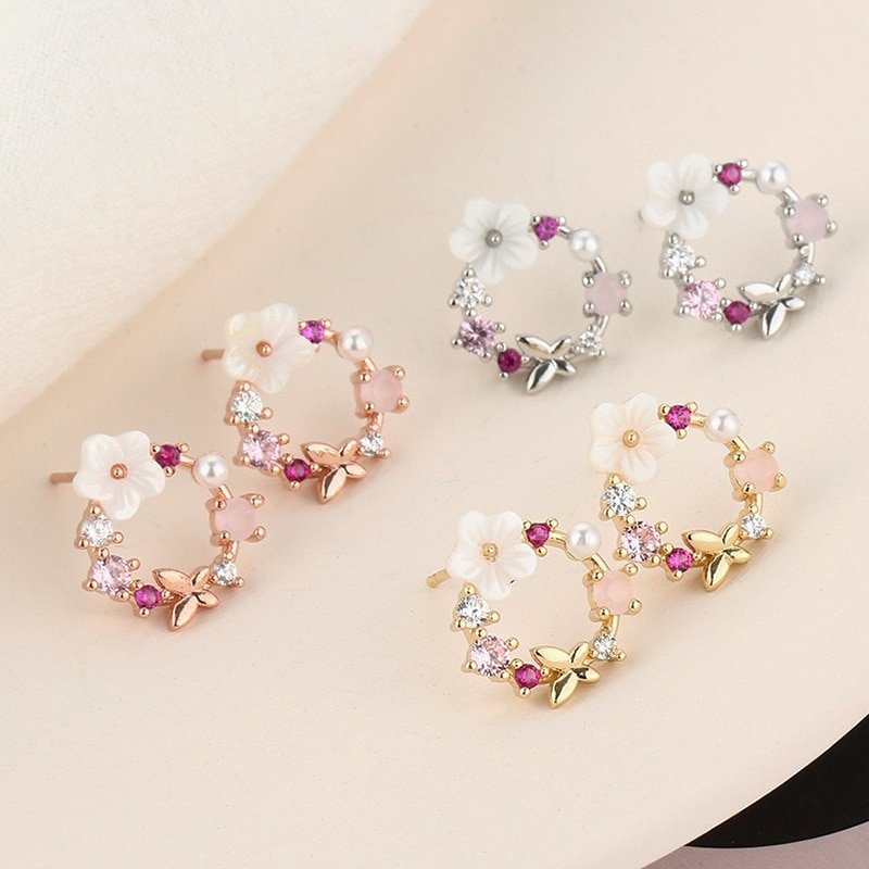 Three pairs of butterfly flower wreath earrings in gold, rose and silver.