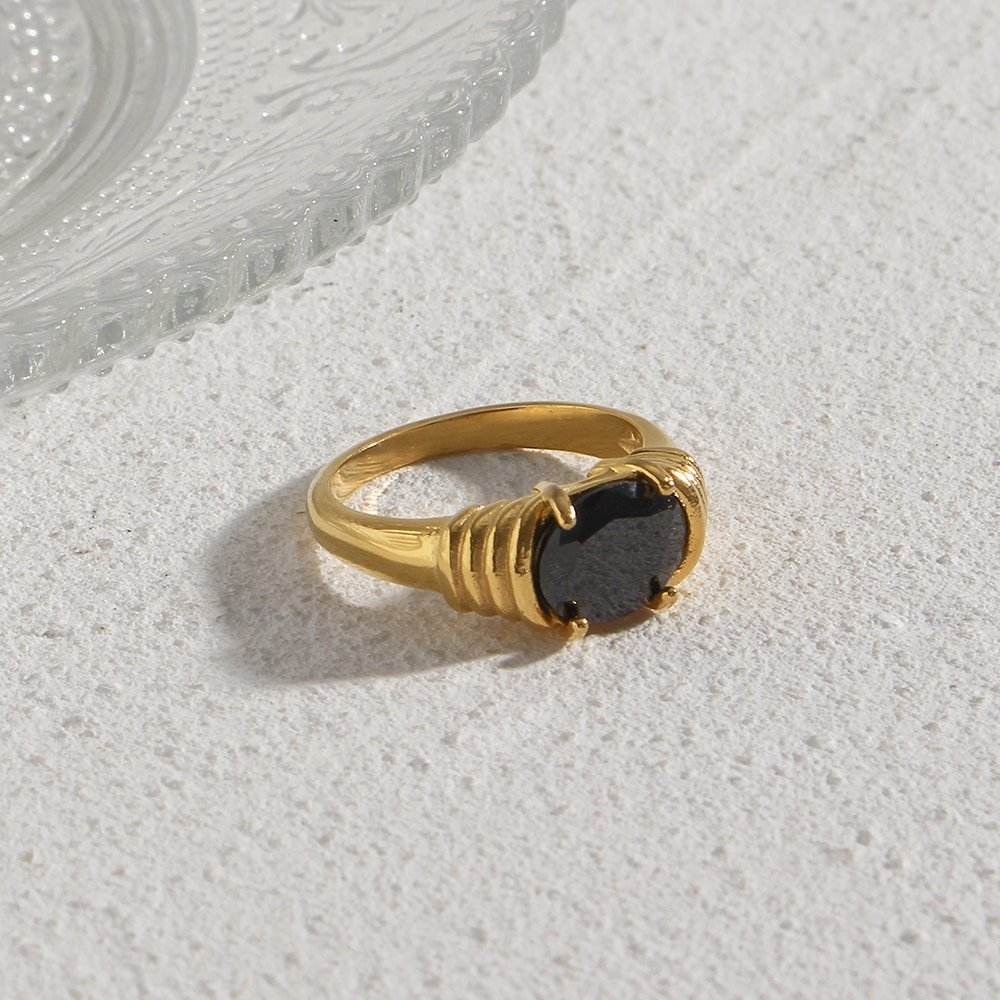 A gold ring with a black gemstone.