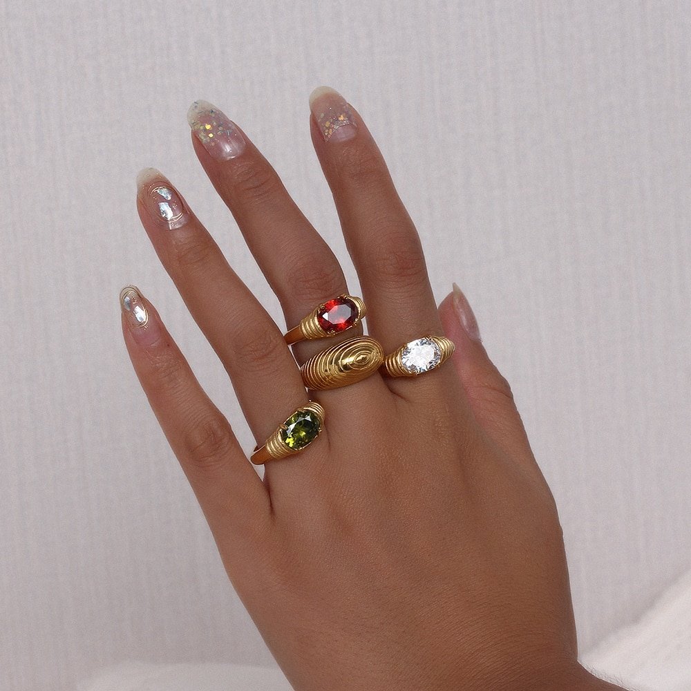 A model wearing chunky gold rings with gemstones.