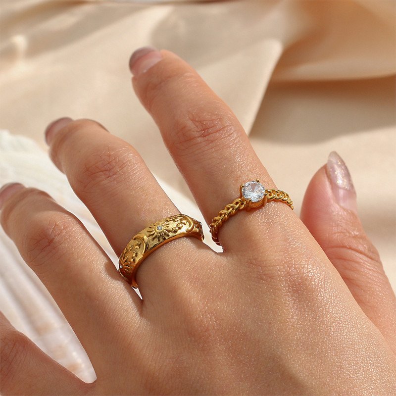 A woman wearing a gold ring with moons, suns, and stars.