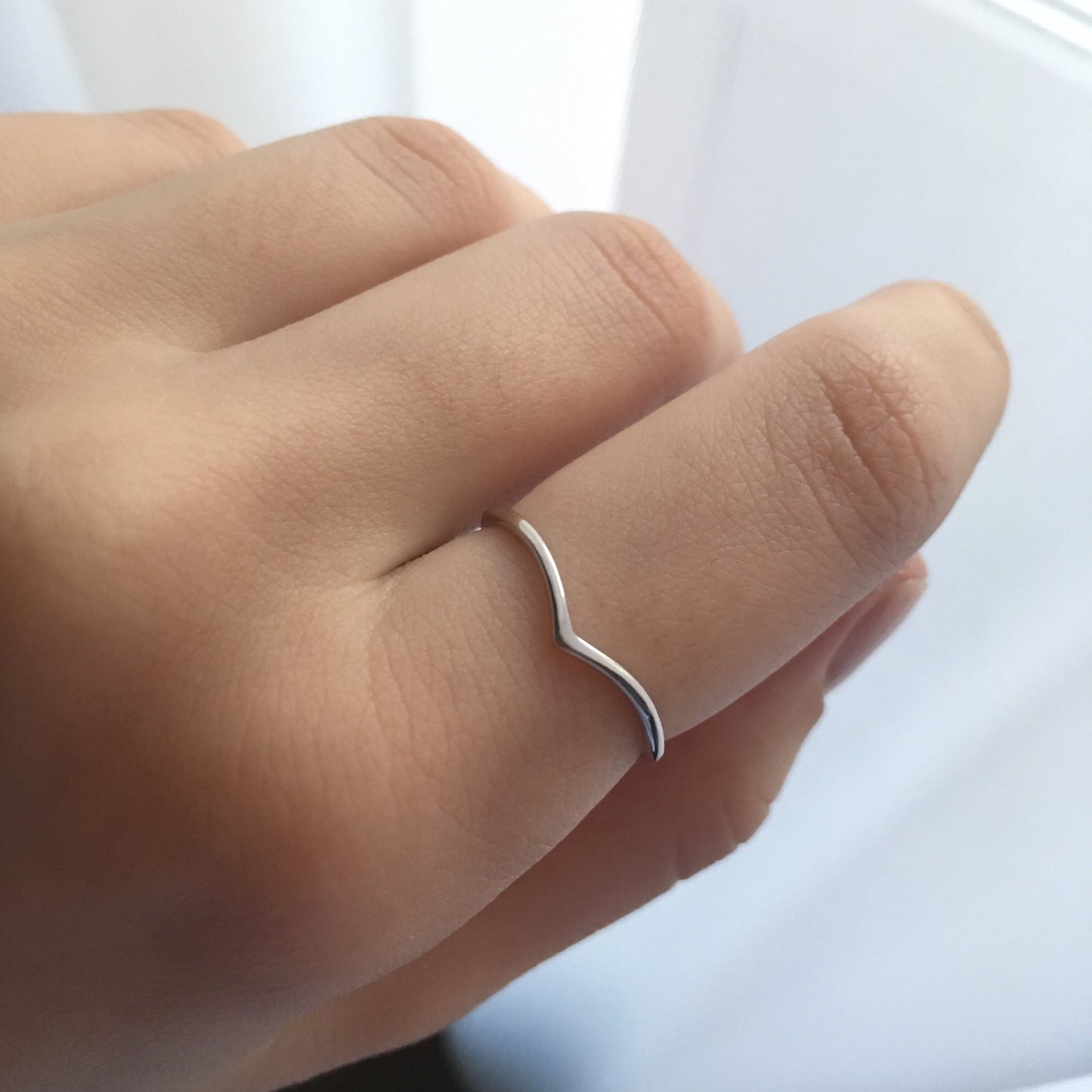 A woman wearing a silver chevron stacking ring.