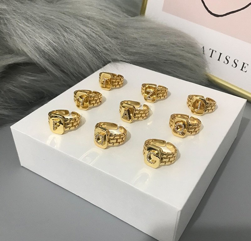 Nine gold rings sitting on a box.
