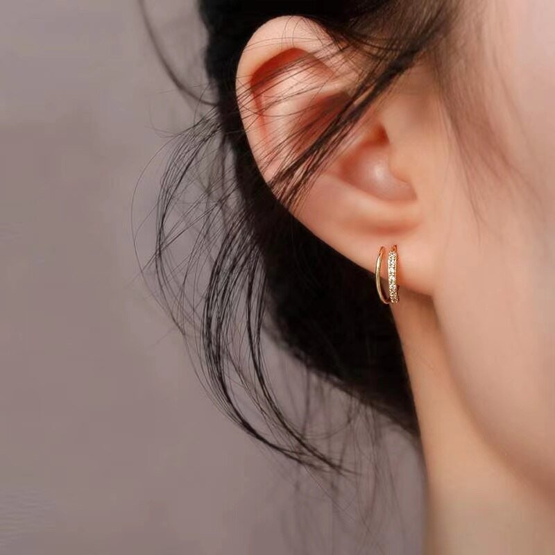 A model wearing a double faux hoop earring.