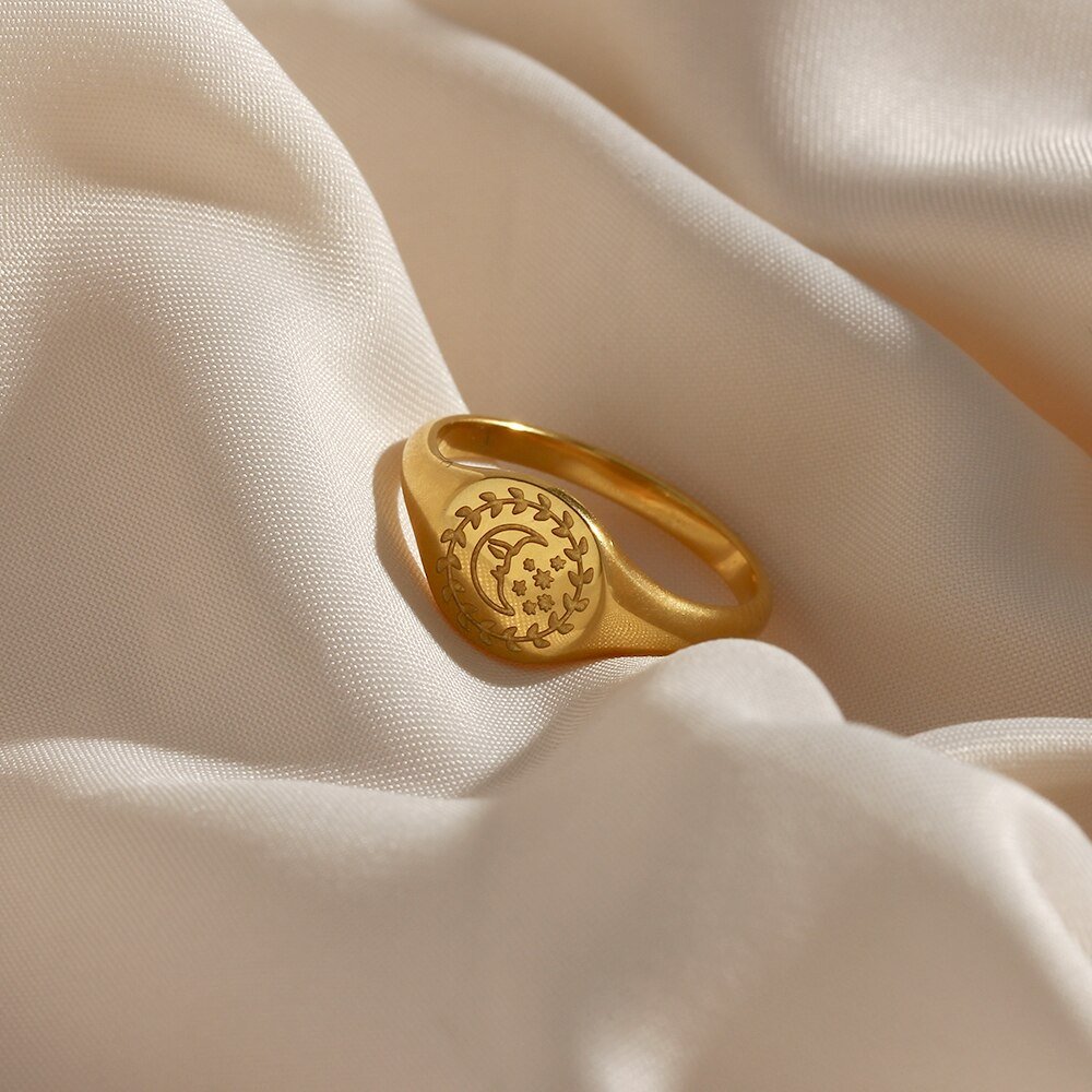 Gold signet ring with a crescent moon engraving.