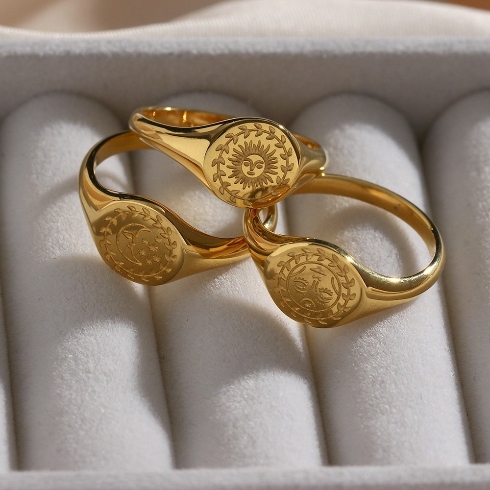Gold signet rings with celestial engravings.