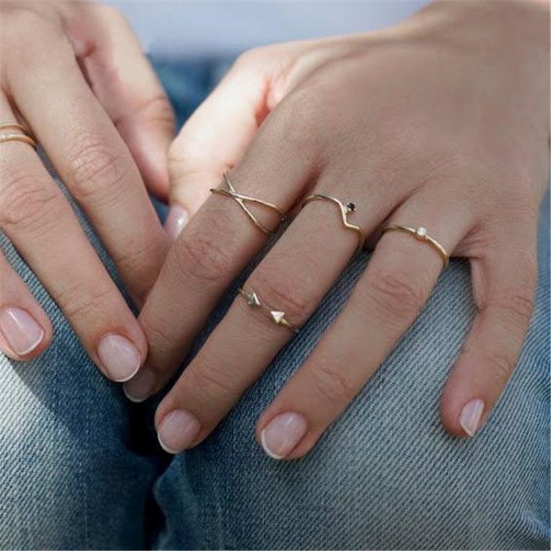 A model wearing multiple gold stacking rings.