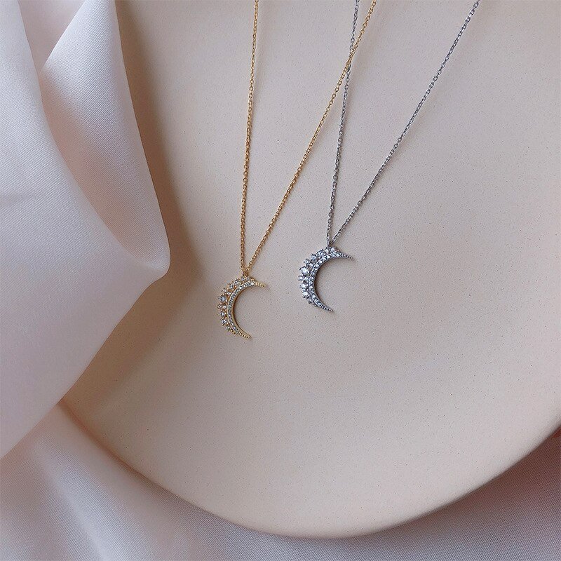Gold and silver crescent moon necklaces.