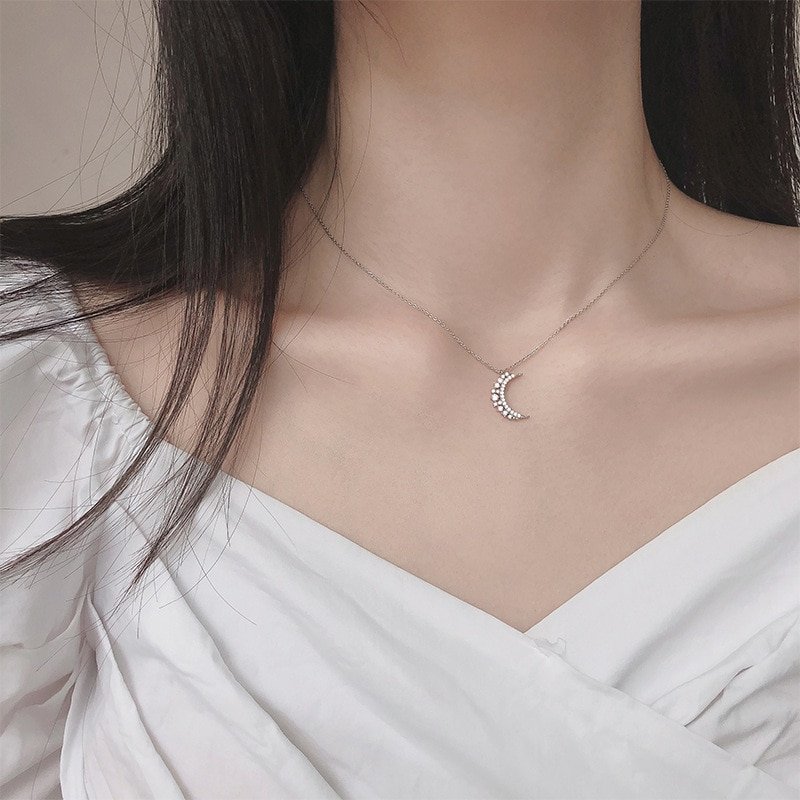 A woman wearing the Crystal Crescent Moon Necklace.