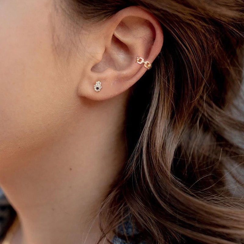 A model wearing the gold Hamsa Hand Studs.