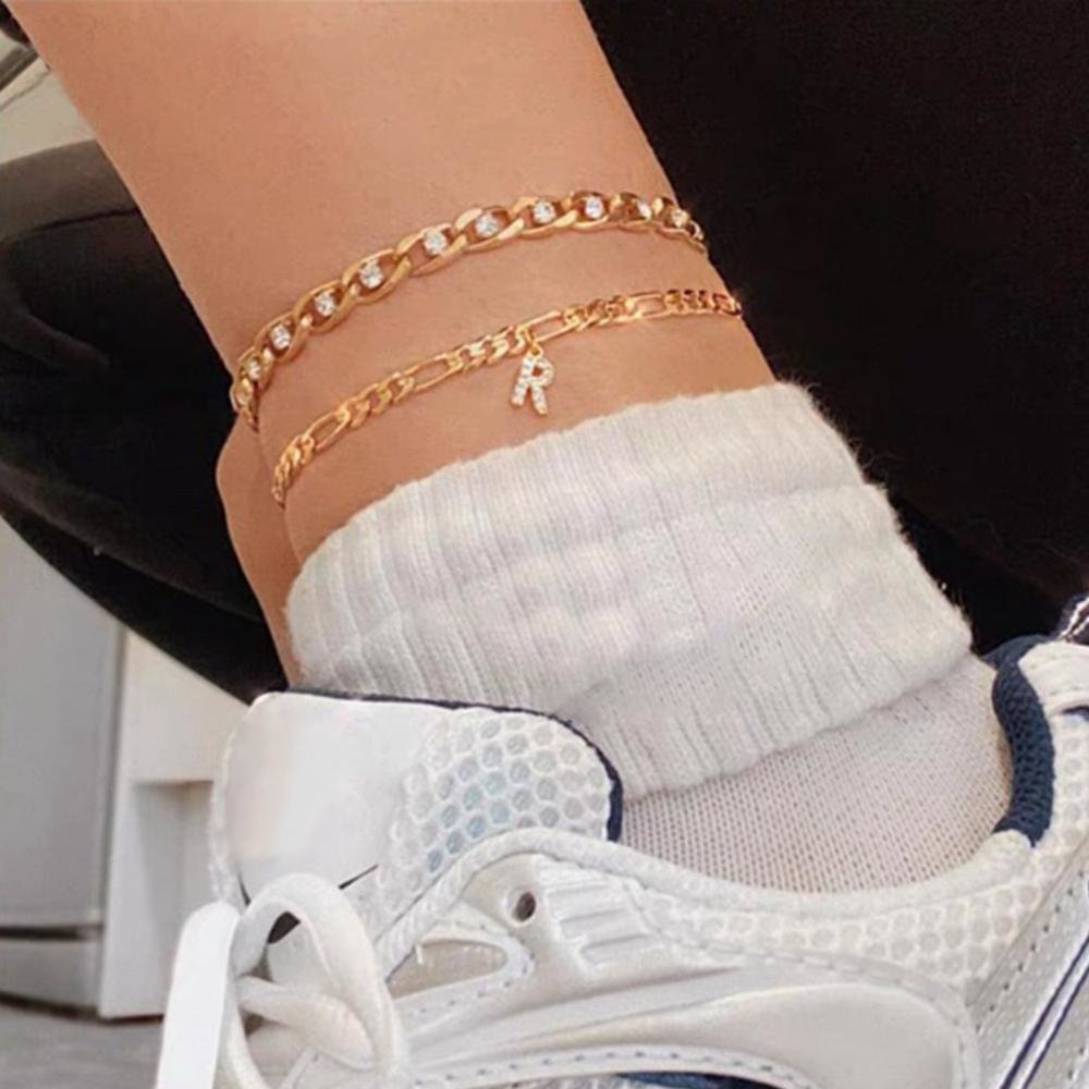 A model wearing the gold Initial Anklet in letter R.