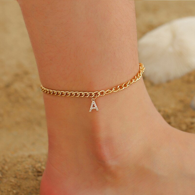 A model wearing a gold Crystal Initial A Anklet.