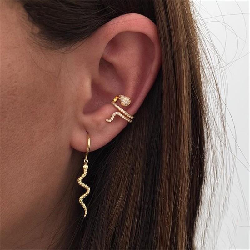 A model wearing the gold snake ear cuff with snake dangle hoops.