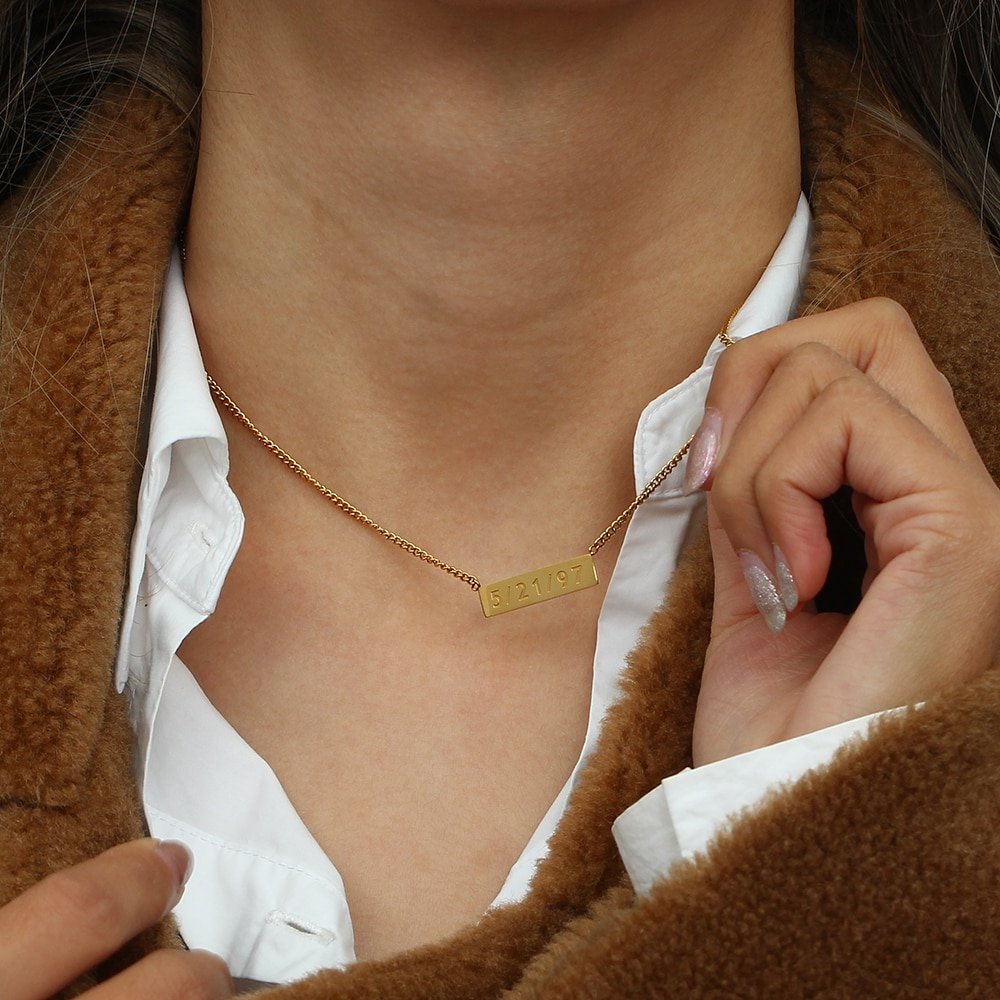 A woman wearing a Custom Name Plate Necklace.
