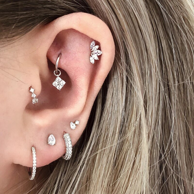 A model wearing a bunch of ear piercings with CZ stones.