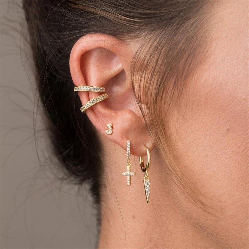 A model wearing gold CZ cross hoop earrings.